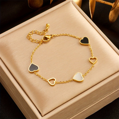 Brazalete Alma Cruz de acero inoxidable con corazones de esmalte negro, blanco y oro, ajustable.
