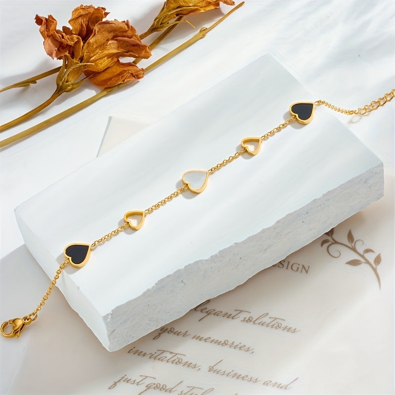 Brazalete Alma Cruz de acero inoxidable dorado con dijes de corazón de esmalte negro y blanco, ajustable.