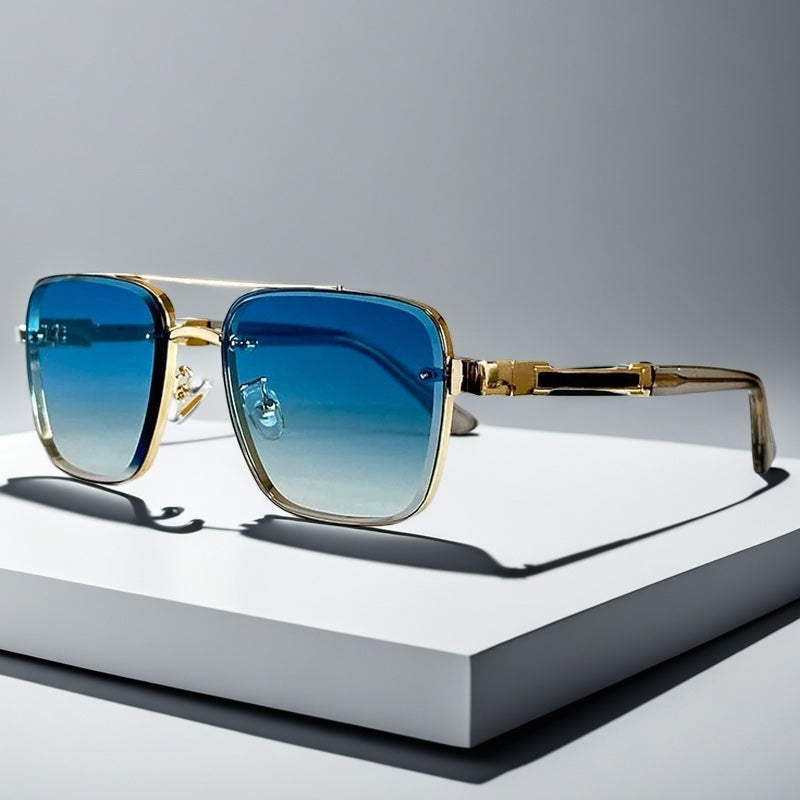 Alma Cruz Gafas de sol aviador doradas con cristales degradados azules y montura cuadrada.