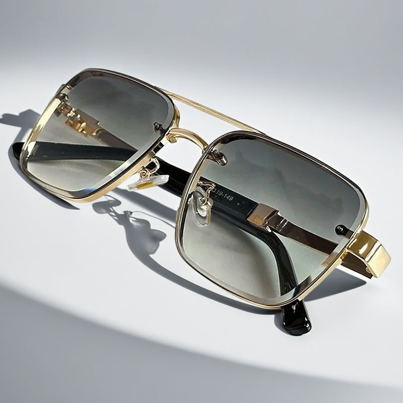 Alma Cruz Gafas de sol doradas estilo aviador con montura cuadrada y cristales degradados.