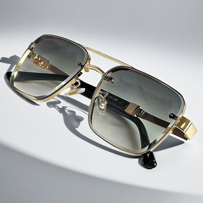 Alma Cruz Gafas de sol doradas estilo aviador con montura cuadrada y cristales degradados.
