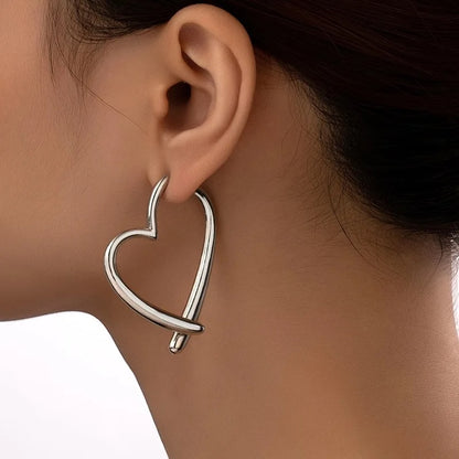 Pendientes de aro plateados con diseño de corazón entrelazado de metal de Alma Cruz.