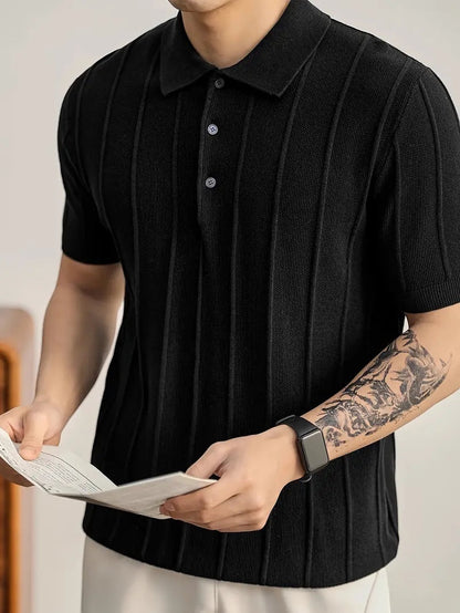 Polo negro de punto de algodón peinado de Alma Cruz con canalé vertical, cuello estructurado y tapeta abierta.