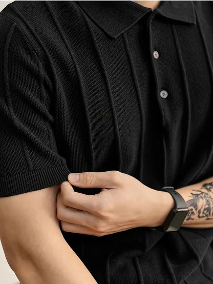 Polo negro de punto de algodón peinado de Alma Cruz con canalé vertical texturizado y cuello estructurado.