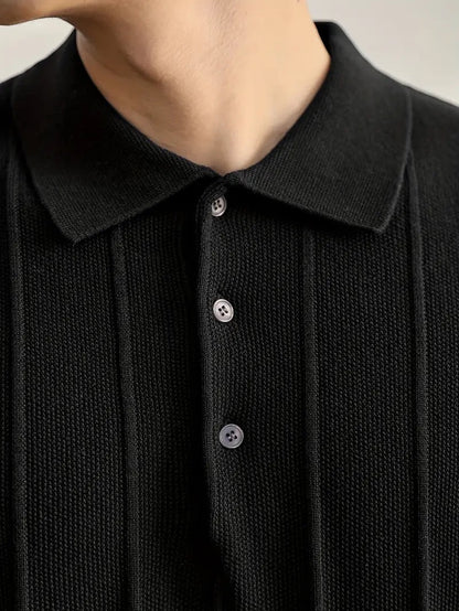 Polo negro de punto de algodón peinado Alma Cruz con canalé vertical y cuello estructurado.
