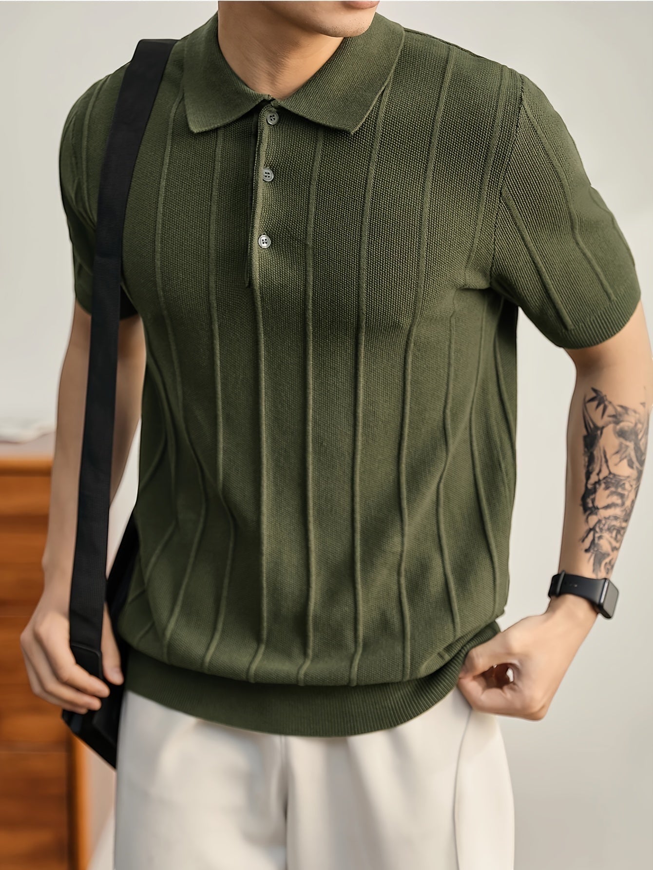 Polo de punto verde oliva de Alma Cruz con canalé vertical, cuello estructurado y tapeta abierta. Corte ajustado.
