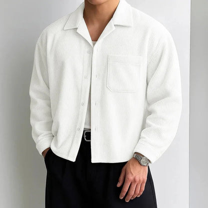 Sobrecamisa blanca de pana de Alma Cruz con cuello abierto y bolsillo en el pecho. Textura acanalada.