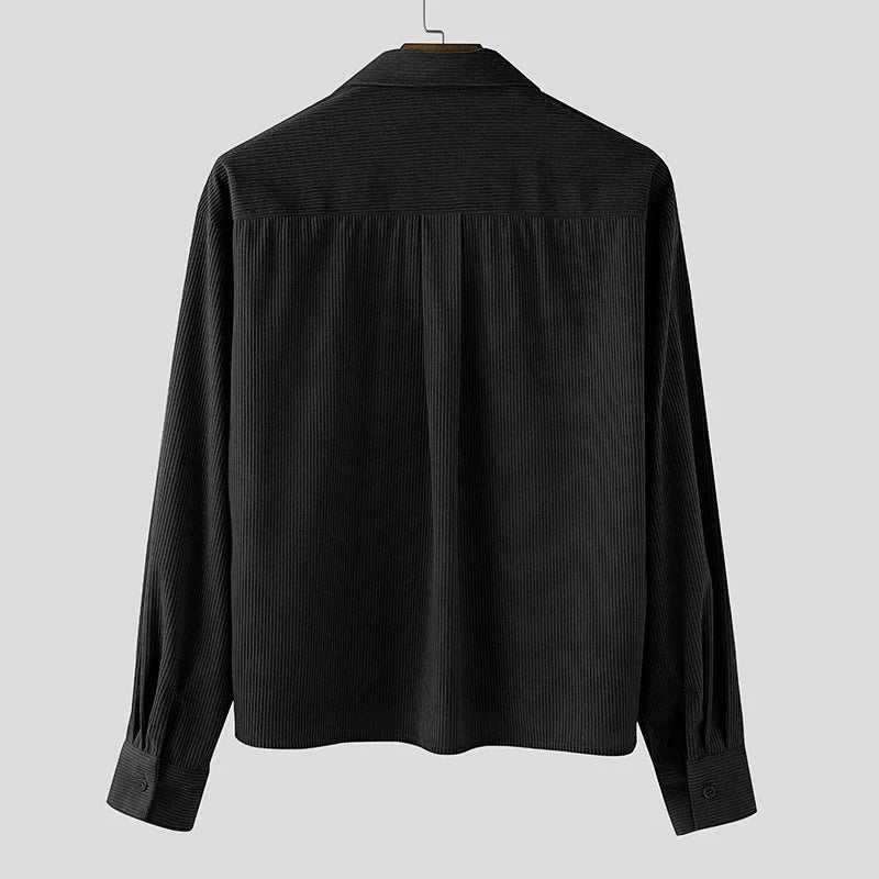 Sobrecamisa negra de pana de Alma Cruz con textura acanalada vertical y botones en el puño.