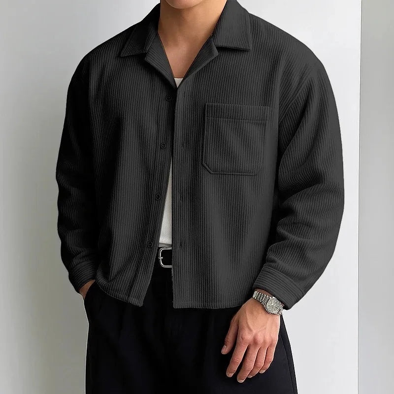 Sobrecamisa negra de pana con textura acanalada y cuello campamento. Prenda de hombre de Alma Cruz.