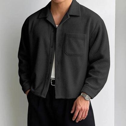 Sobrecamisa negra de pana con textura acanalada y cuello campamento. Prenda de hombre de Alma Cruz.