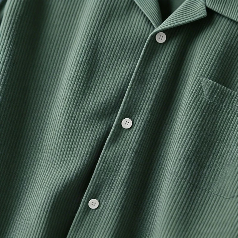 Sobrecamisa verde de pana de Alma Cruz con cuello abierto, botones y bolsillo en el pecho. Textura acanalada vertical.