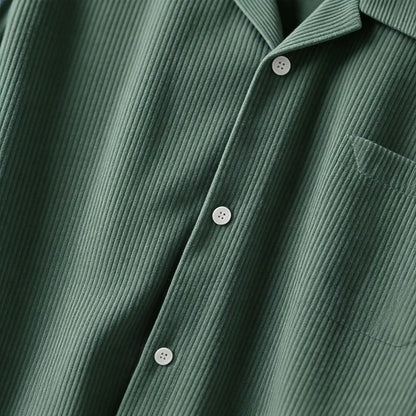 Sobrecamisa verde de pana de Alma Cruz con cuello abierto, botones y bolsillo en el pecho. Textura acanalada vertical.