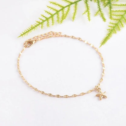 Tobillera dorada de cobre con charm de estrella de mar, estilo delicado y versátil.