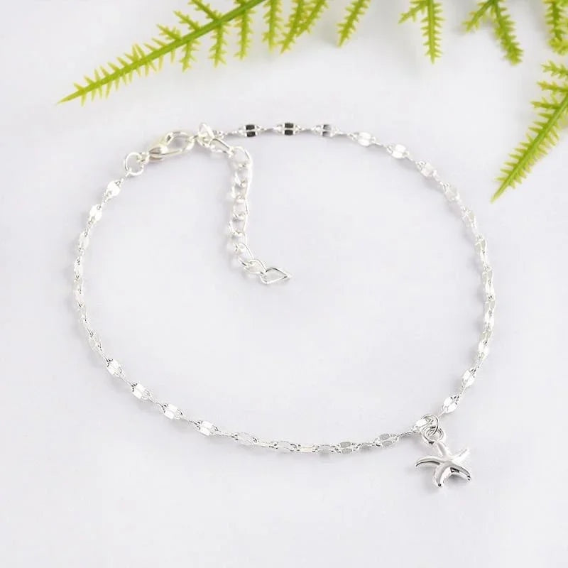 Tobillera plateada de Alma Cruz con cadena delicada y charm de estrella de mar. Elegante y versátil.