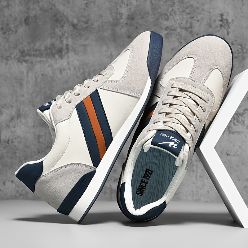 Zapatillas deportivas Alma Cruz de piel en blanco y gris con detalles azul marino y naranja. Diseño retro.