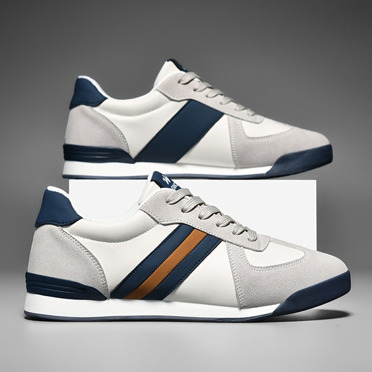 Zapatillas deportivas Alma Cruz de piel blanca y ante gris con detalles azul marino y marrón. Diseño retro.